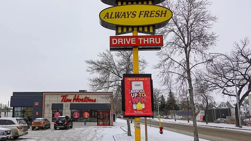 A Tim Hortons sign reading Always Fresh and Drive Thru outside a restaurant in Winnipeg, Manitoba